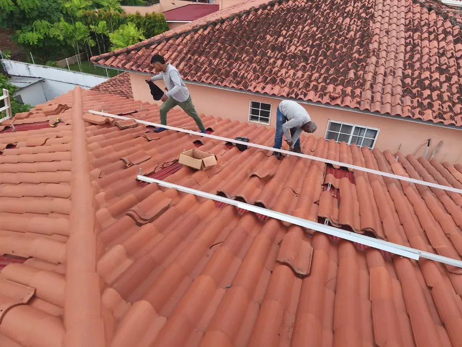 Técnicos de INSOSA montando la estructura de soporte de paneles solares sobre techo de tejas